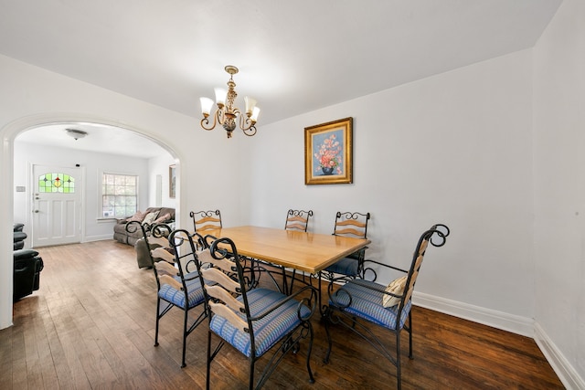 dining room with dark hardwood / wood-style flooring and a chandelier