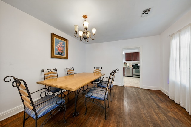 dining room with a notable chandelier and dark hardwood / wood-style flooring