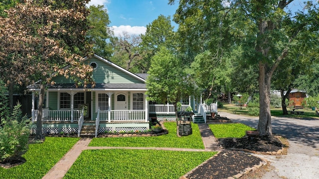 farmhouse-style home featuring covered porch and a front yard