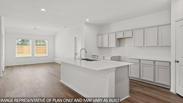 kitchen featuring gray cabinetry, dark hardwood / wood-style flooring, sink, and a kitchen island with sink