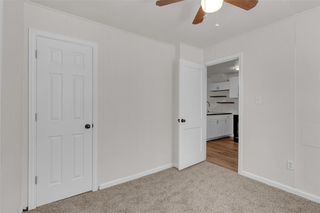 unfurnished bedroom featuring light carpet and ceiling fan