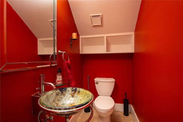 bathroom with tile patterned floors, sink, lofted ceiling, and toilet