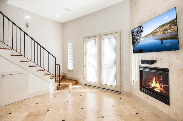 entryway featuring french doors and a tiled fireplace