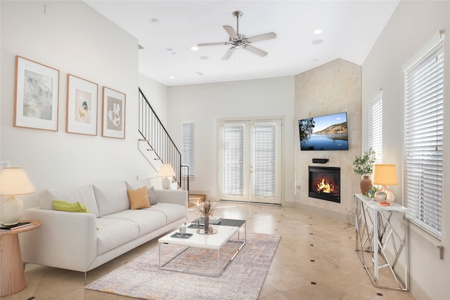 tiled living room with ceiling fan and a fireplace