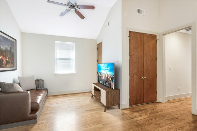 living room with light wood-type flooring, vaulted ceiling, and ceiling fan