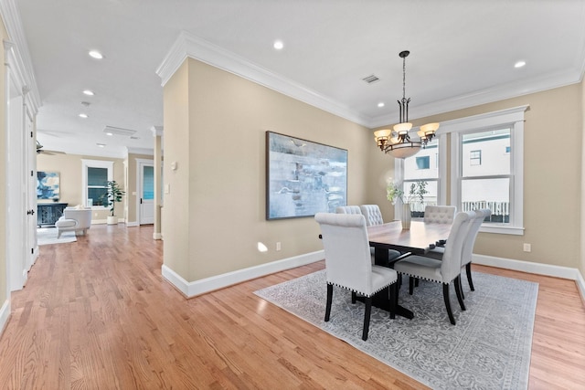 dining room featuring an inviting chandelier, crown molding, and light hardwood / wood-style floors