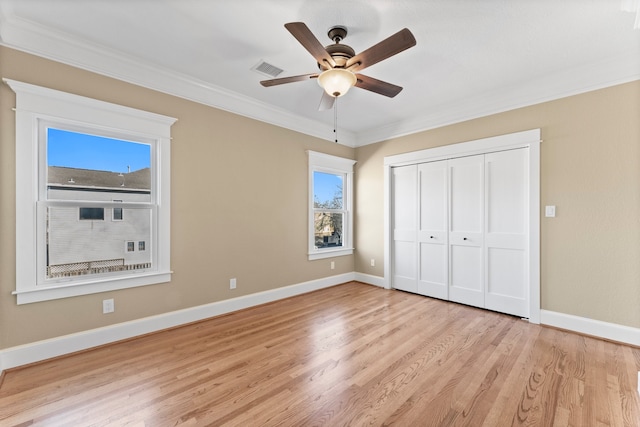 unfurnished bedroom featuring light hardwood / wood-style floors, ornamental molding, a closet, and ceiling fan