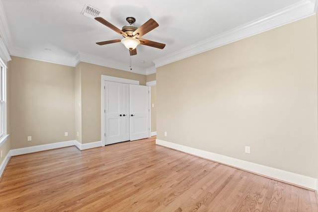 empty room with ornamental molding, ceiling fan, and light hardwood / wood-style flooring