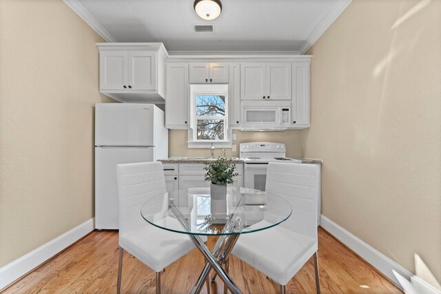 501 Cordell St, Houston, TX 77009 - kitchen featuring white appliances, baseboards, crown molding, white cabinets, and light wood-style flooring