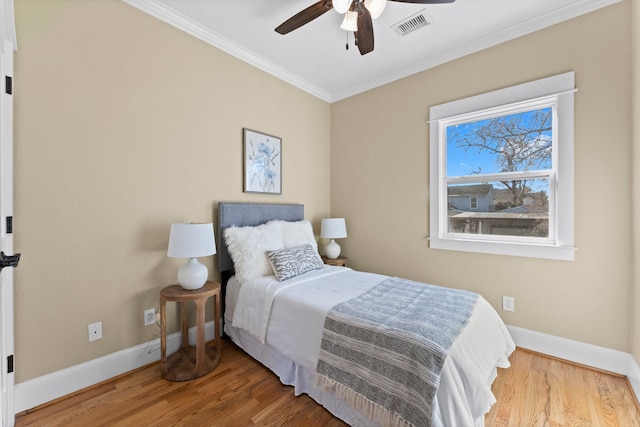 bedroom with ornamental molding, hardwood / wood-style floors, and ceiling fan