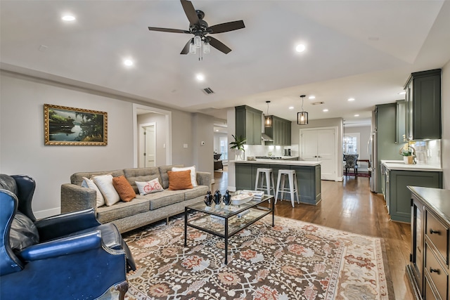 living room featuring dark hardwood / wood-style flooring and ceiling fan