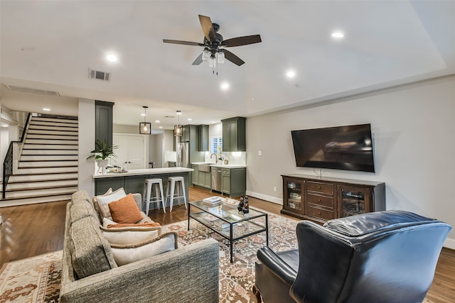 living room featuring ceiling fan, wood-type flooring, and lofted ceiling