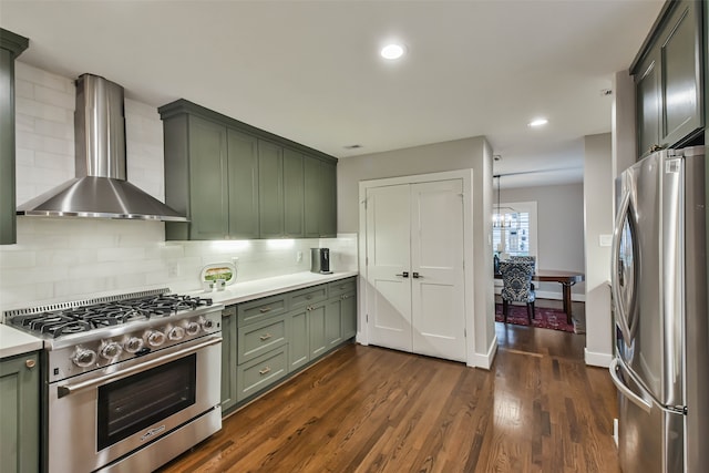 kitchen featuring decorative backsplash, green cabinetry, stainless steel appliances, dark wood-type flooring, and wall chimney exhaust hood