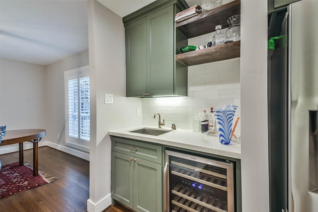 bar featuring stainless steel fridge, sink, beverage cooler, and green cabinetry