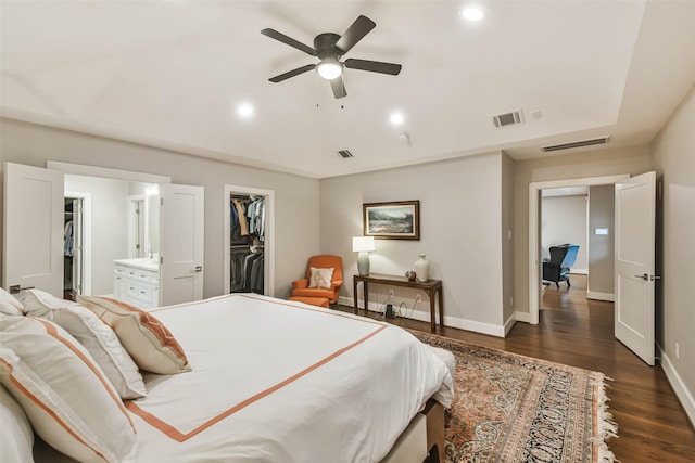 bedroom featuring lofted ceiling, ensuite bath, a spacious closet, dark hardwood / wood-style flooring, and a closet