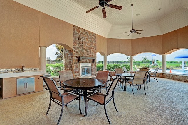 view of patio / terrace featuring an outdoor stone fireplace and ceiling fan