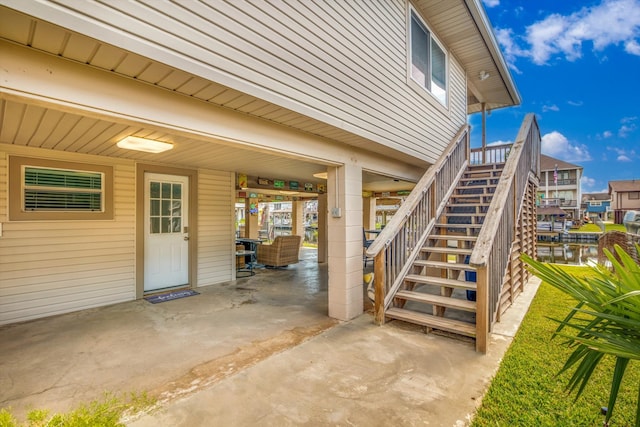 property entrance featuring a patio area and a water view