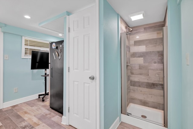 bathroom featuring a shower with door and hardwood / wood-style floors