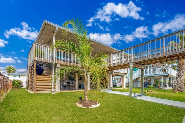 rear view of property with a yard and a wooden deck