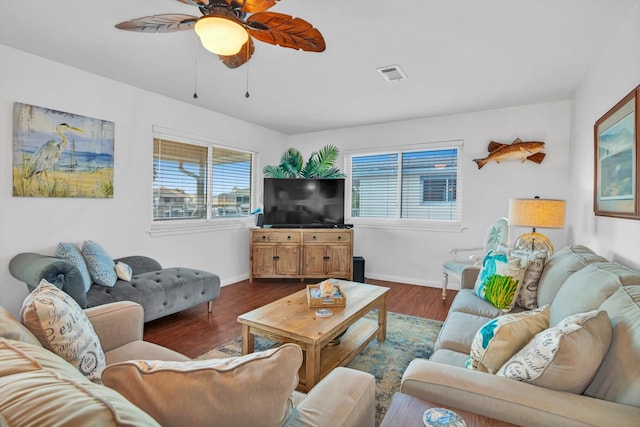 living room featuring dark wood-type flooring and ceiling fan