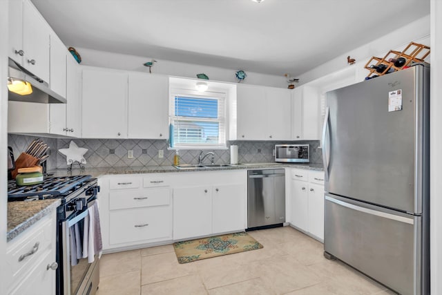 kitchen featuring sink, light stone countertops, white cabinets, appliances with stainless steel finishes, and tasteful backsplash