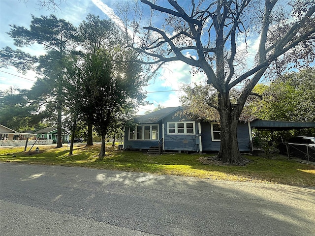 view of front of house with a front yard and a carport