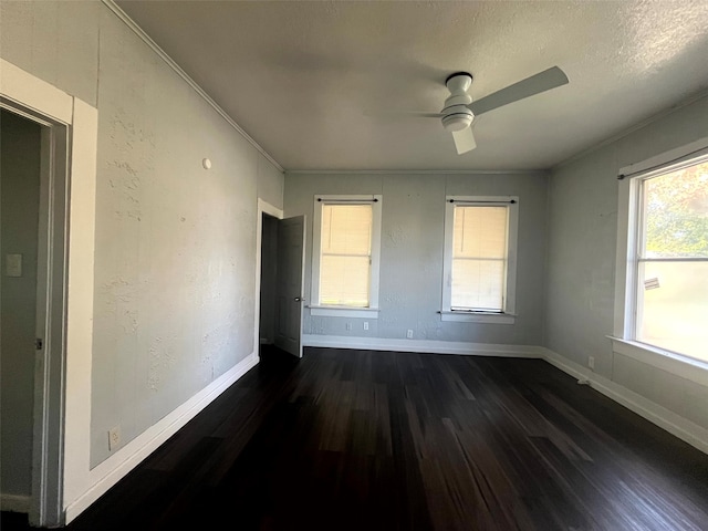 unfurnished bedroom featuring crown molding, a textured ceiling, dark wood-type flooring, and ceiling fan