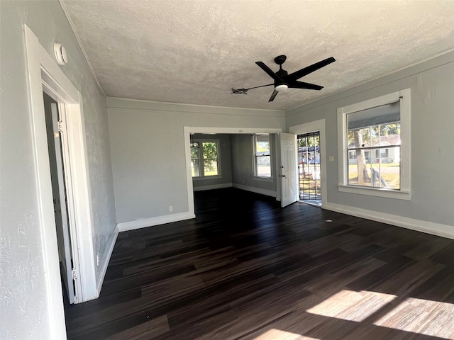 unfurnished room with a healthy amount of sunlight, ceiling fan, and dark hardwood / wood-style flooring