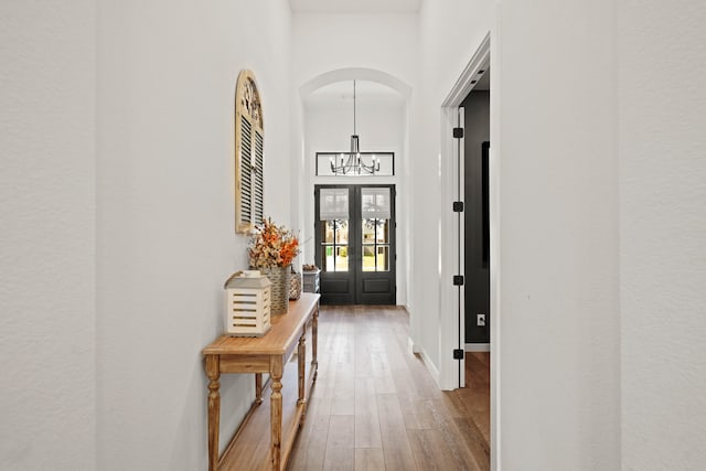 interior space featuring french doors, a notable chandelier, and wood-type flooring