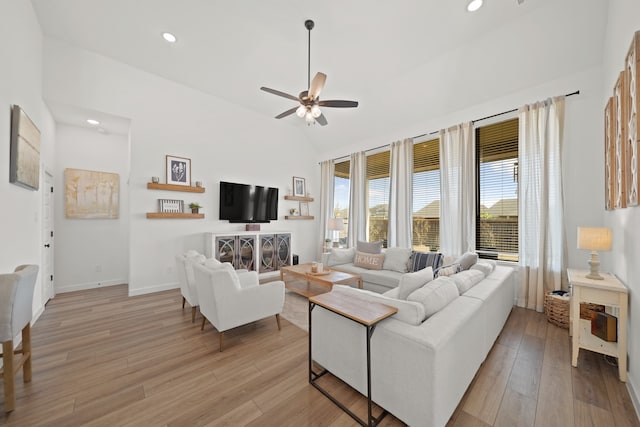 living room with lofted ceiling, light hardwood / wood-style floors, and ceiling fan