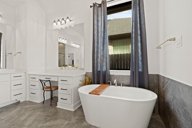 bathroom with a bath, tile walls, tile patterned flooring, and vanity