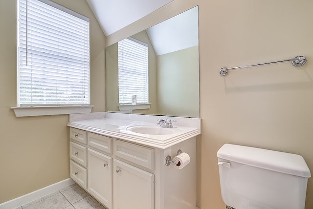 bathroom featuring toilet, vanity, plenty of natural light, and vaulted ceiling