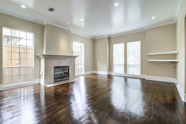 unfurnished living room featuring ornamental molding, hardwood / wood-style floors, and a tile fireplace