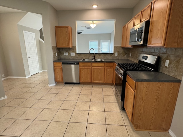 kitchen with sink, stainless steel appliances, backsplash, and light tile patterned floors