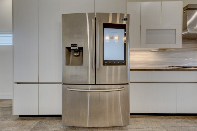 kitchen with white cabinetry, stainless steel refrigerator with ice dispenser, tasteful backsplash, and extractor fan