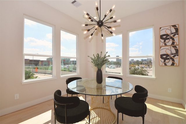 dining area with a notable chandelier and light hardwood / wood-style floors