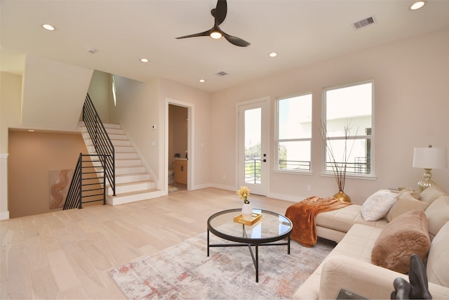 living room with light hardwood / wood-style floors and ceiling fan