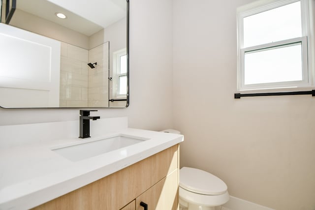 bathroom featuring vanity, walk in shower, and toilet