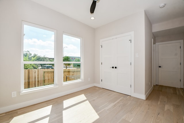 unfurnished bedroom with a closet, light hardwood / wood-style floors, and ceiling fan