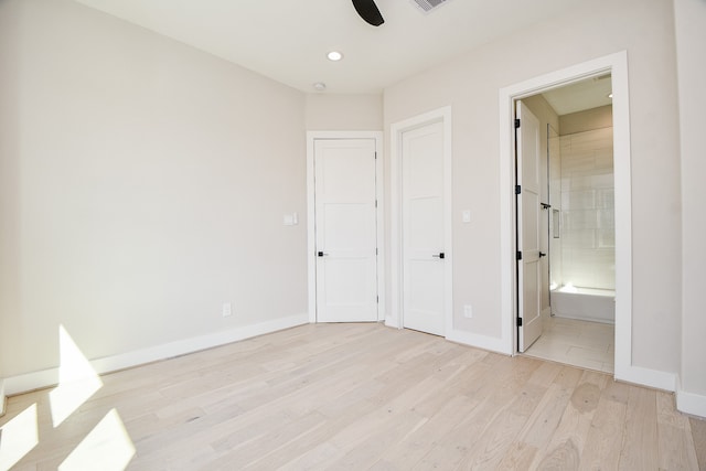 unfurnished bedroom featuring connected bathroom, light wood-type flooring, and ceiling fan