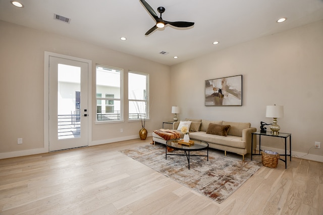 living room featuring light hardwood / wood-style floors and ceiling fan