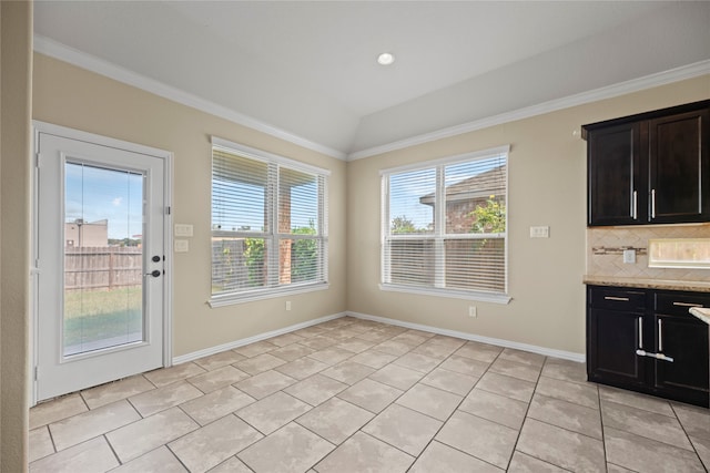 unfurnished dining area featuring lofted ceiling, light tile patterned flooring, and crown molding