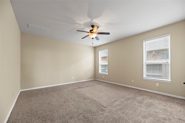 carpeted empty room with a healthy amount of sunlight and ceiling fan