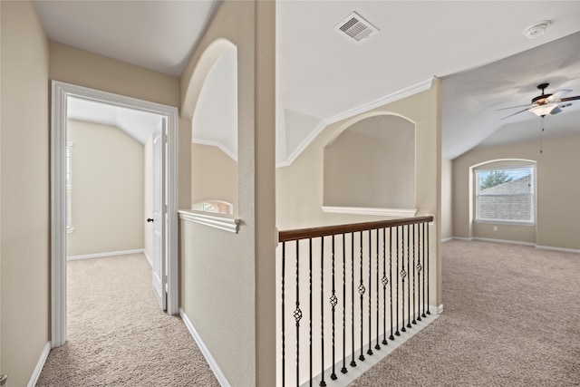 hall with lofted ceiling and light carpet