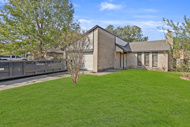 rear view of house featuring a yard and a garage