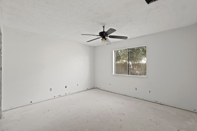 unfurnished room with ceiling fan and a textured ceiling