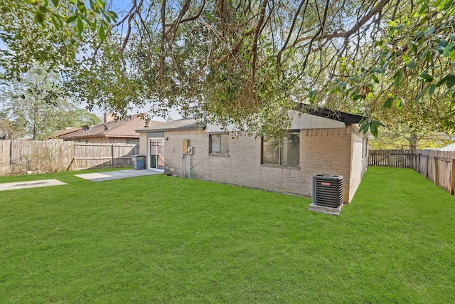 rear view of house with central air condition unit, a patio area, and a lawn