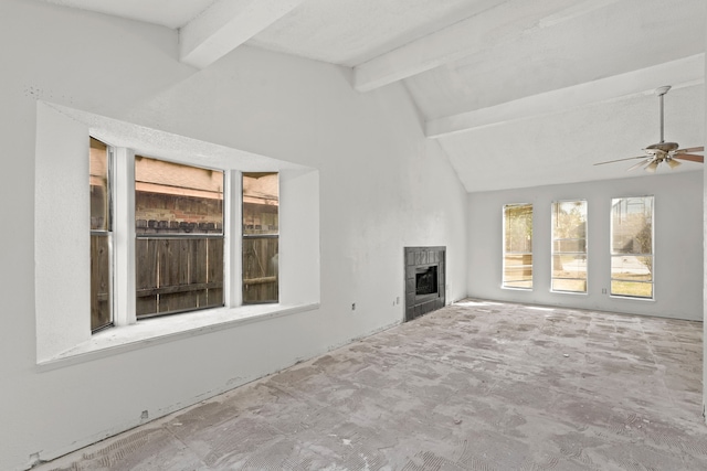 unfurnished living room featuring lofted ceiling with beams, a tiled fireplace, and ceiling fan