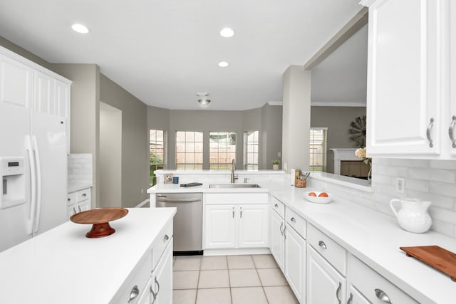 kitchen featuring kitchen peninsula, sink, white fridge with ice dispenser, and dishwasher