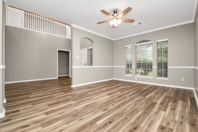 unfurnished living room with hardwood / wood-style floors, ceiling fan, and crown molding